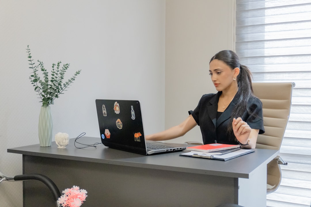 Woman working on laptop at desk in office desk.
