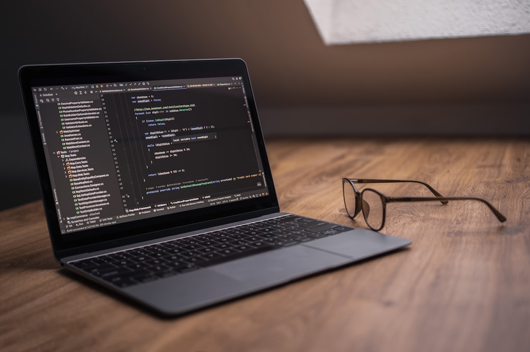Laptop displaying code with glasses on desk